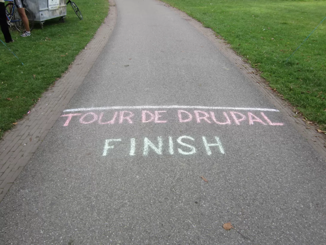 Image of a paved road with the text "Tour de Drupal, Finish"