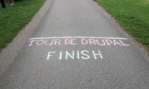 Image of a paved road with the text "Tour de Drupal, Finish"