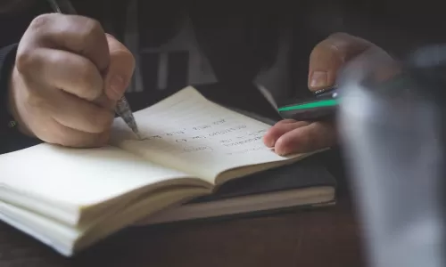 A person taking notes in a notebook