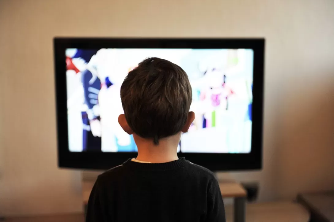 A child in front of a tv