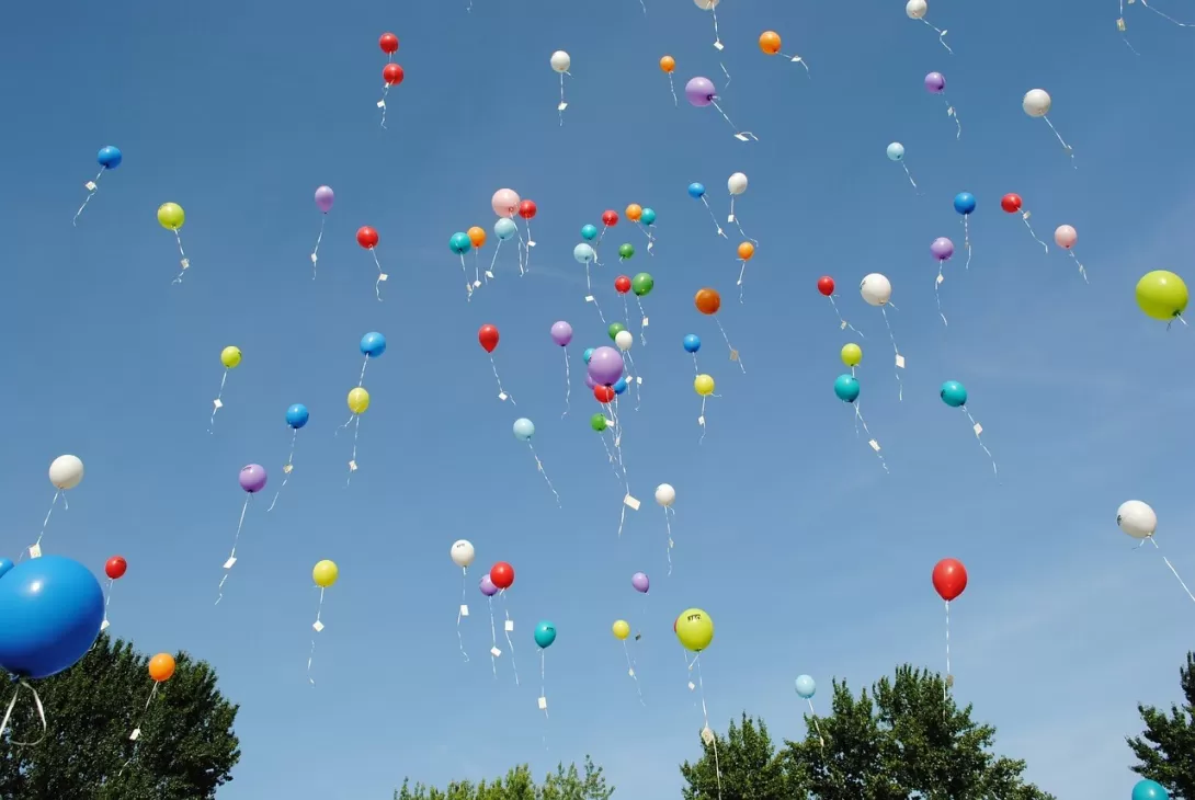 A bunch of balloons drifting off into the sky